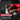 Hands peel adhesive from sneaker insert, seated on couch with red hoodie in blurred background.